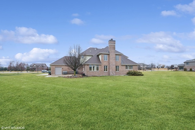 back of property featuring a garage and a lawn