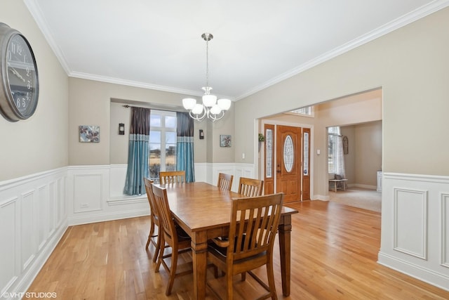 dining space featuring a notable chandelier, crown molding, and light hardwood / wood-style floors