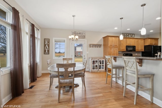 dining space featuring a notable chandelier and light hardwood / wood-style flooring