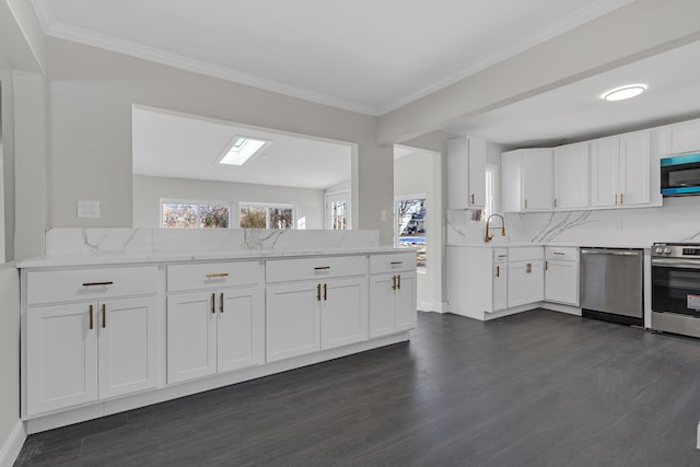 kitchen with white cabinetry, appliances with stainless steel finishes, and kitchen peninsula