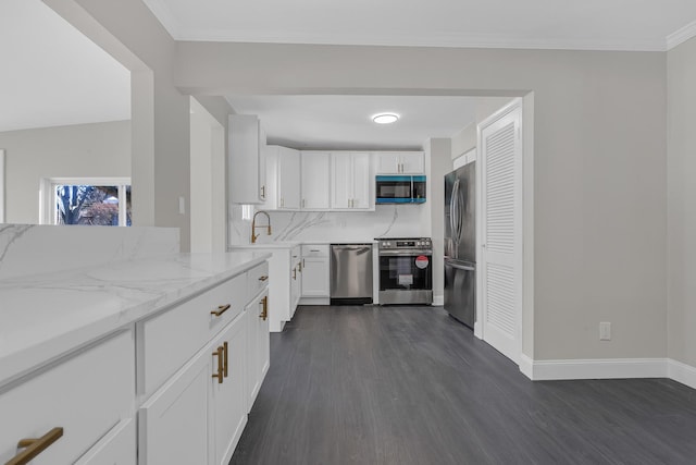 kitchen with sink, dark wood-type flooring, white cabinetry, stainless steel appliances, and light stone counters