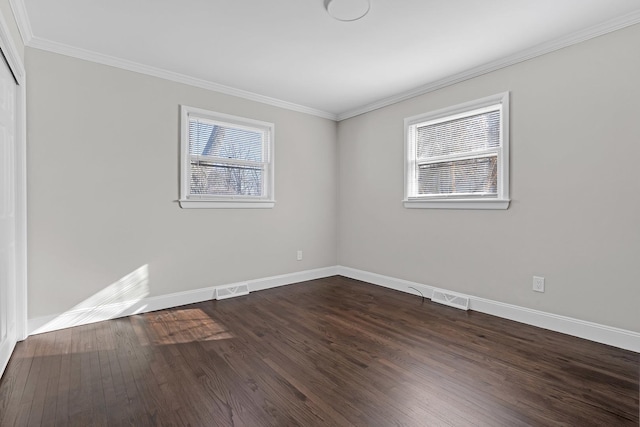 spare room with ornamental molding and dark hardwood / wood-style flooring