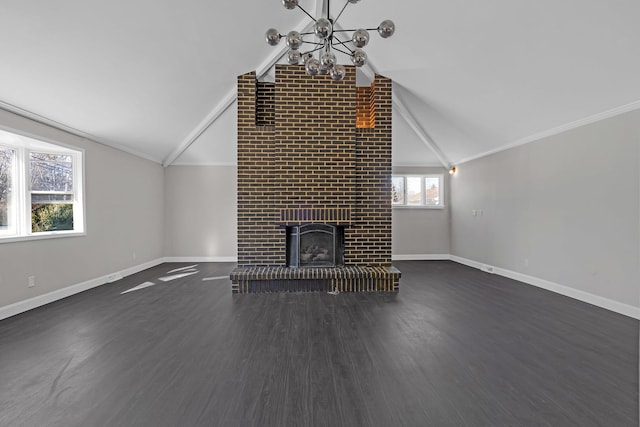 unfurnished living room featuring dark hardwood / wood-style floors, a fireplace, lofted ceiling, ornamental molding, and an inviting chandelier