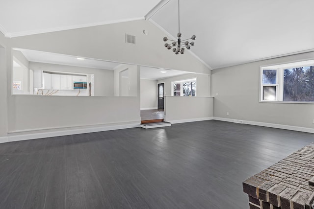 unfurnished living room featuring dark hardwood / wood-style flooring, a wealth of natural light, vaulted ceiling, and a chandelier