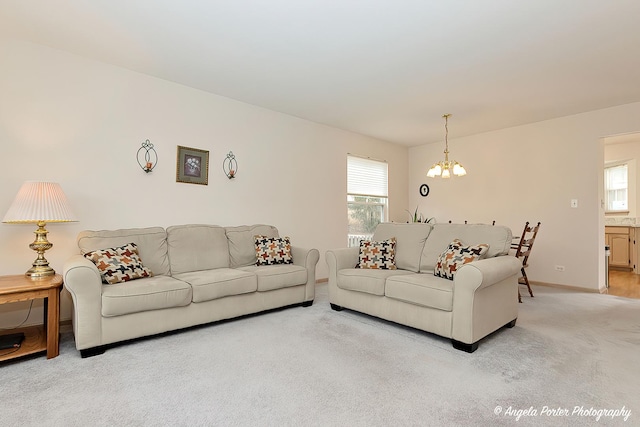 carpeted living room featuring plenty of natural light and a chandelier