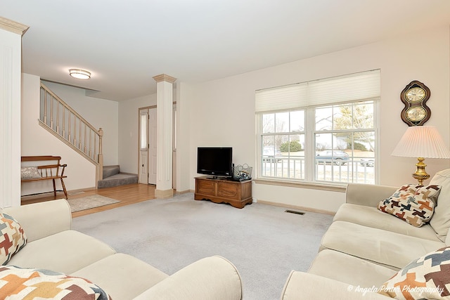 living room with decorative columns and light colored carpet