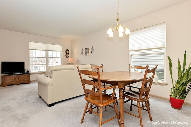 carpeted dining space featuring a notable chandelier