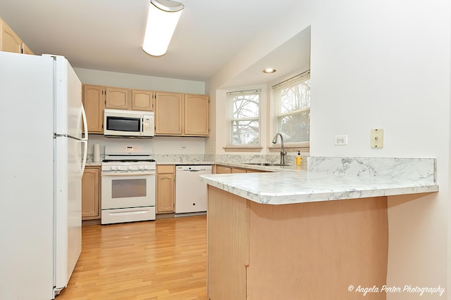 kitchen with light brown cabinetry, sink, kitchen peninsula, white appliances, and light hardwood / wood-style floors