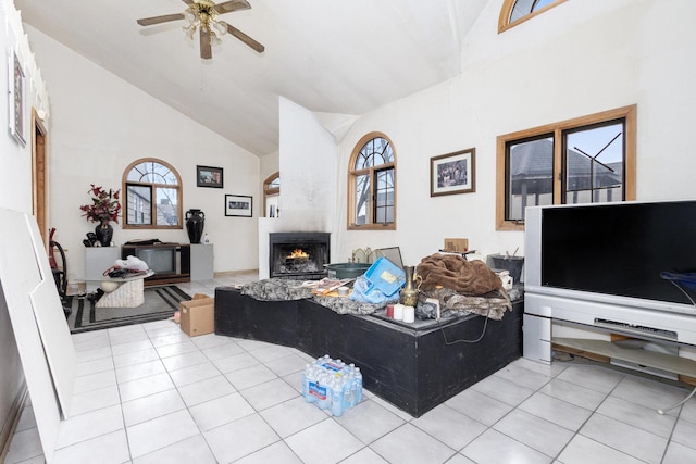 living room with light tile patterned flooring, ceiling fan, and high vaulted ceiling