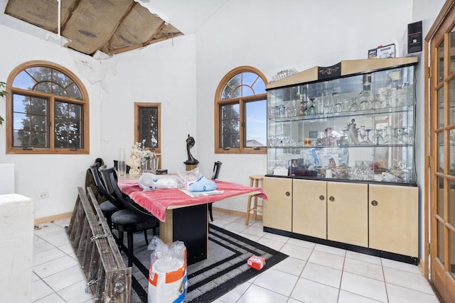 tiled dining room featuring a towering ceiling