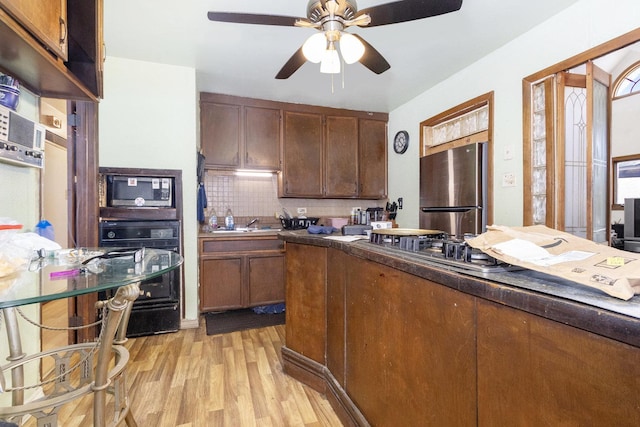 kitchen featuring ceiling fan, appliances with stainless steel finishes, backsplash, and light wood-type flooring