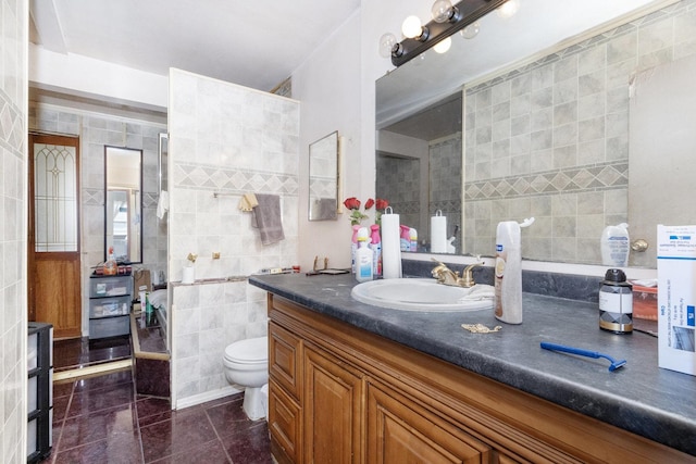 bathroom with vanity, tile walls, tile patterned floors, and toilet