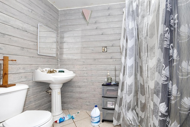 bathroom featuring wooden walls, tile patterned floors, and toilet