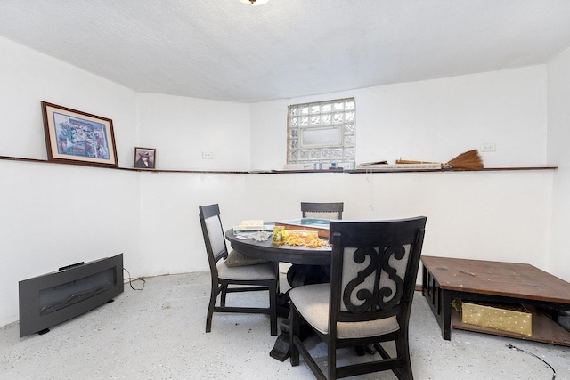 dining space featuring concrete floors and a textured ceiling