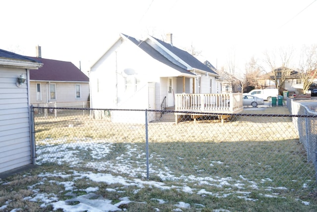 snow covered rear of property with a lawn