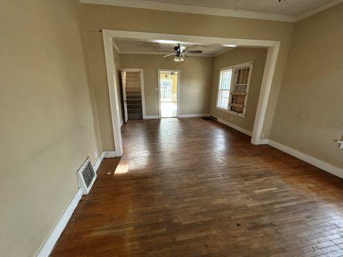 spare room featuring dark wood-type flooring, ornamental molding, and ceiling fan