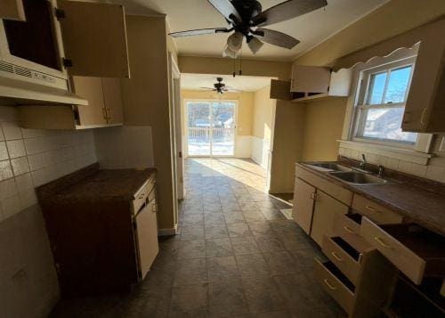 kitchen featuring tasteful backsplash, sink, and ceiling fan