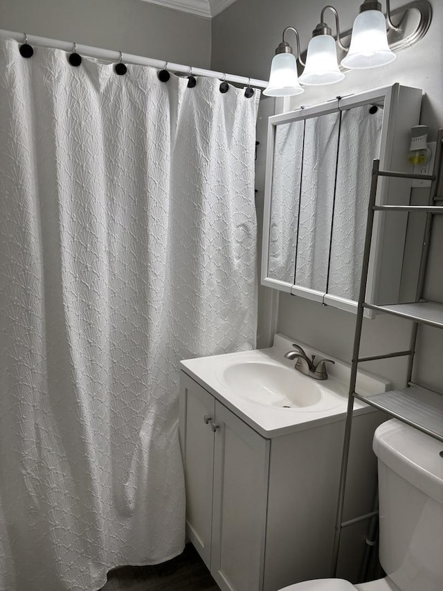 bathroom featuring crown molding, walk in shower, vanity, and toilet