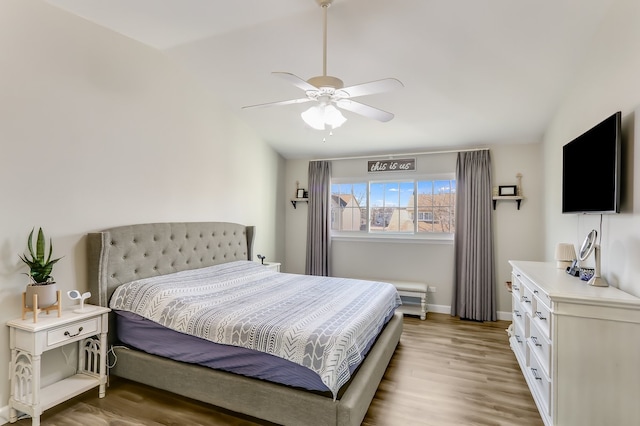 bedroom with ceiling fan, lofted ceiling, and light hardwood / wood-style flooring