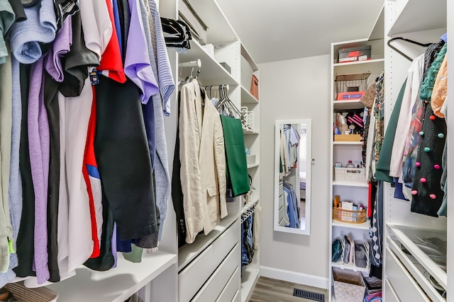 walk in closet with light hardwood / wood-style floors