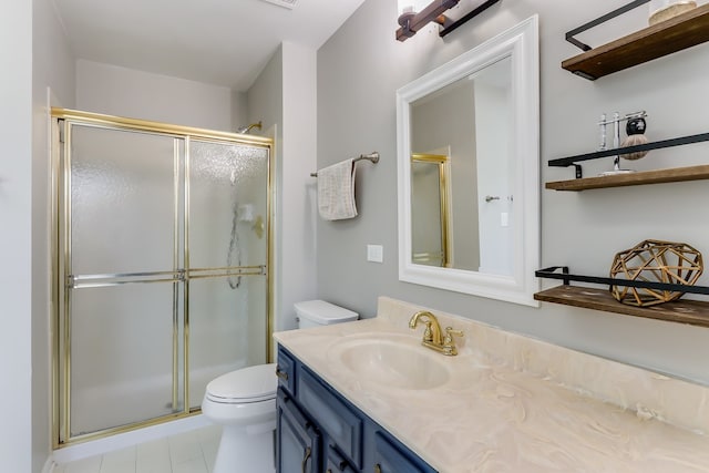 bathroom with vanity, toilet, and a shower with shower door