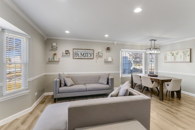 living room with ornamental molding, a chandelier, and light wood-type flooring