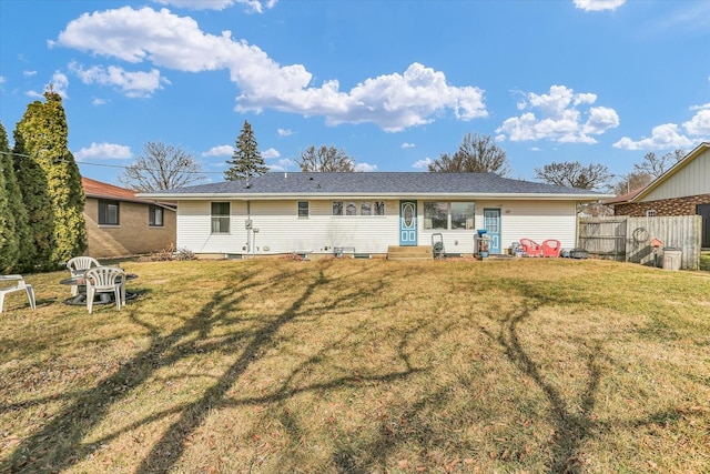 rear view of property featuring a lawn