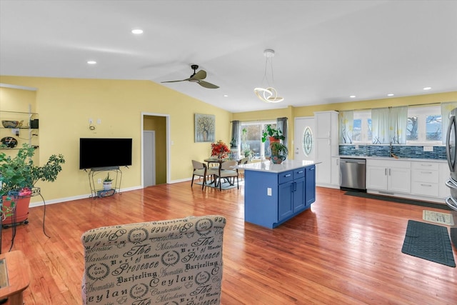 kitchen featuring sink, white cabinets, hanging light fixtures, stainless steel appliances, and blue cabinetry