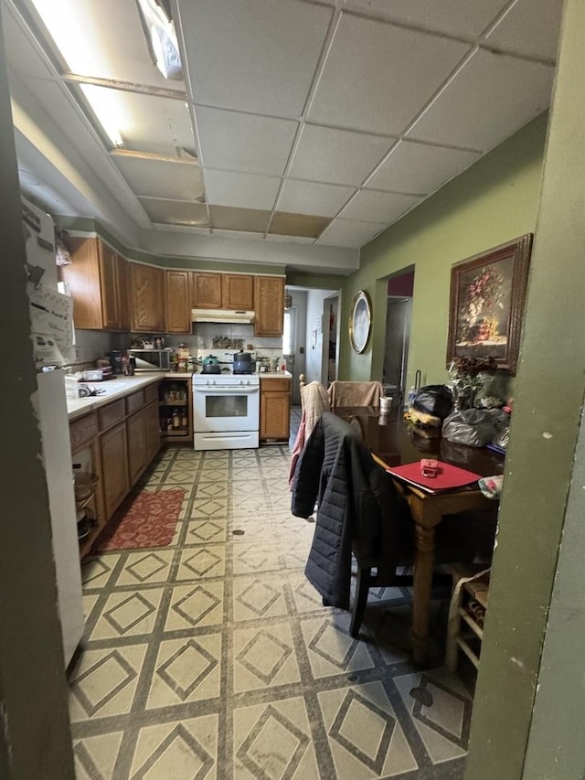 kitchen with a drop ceiling and white stove