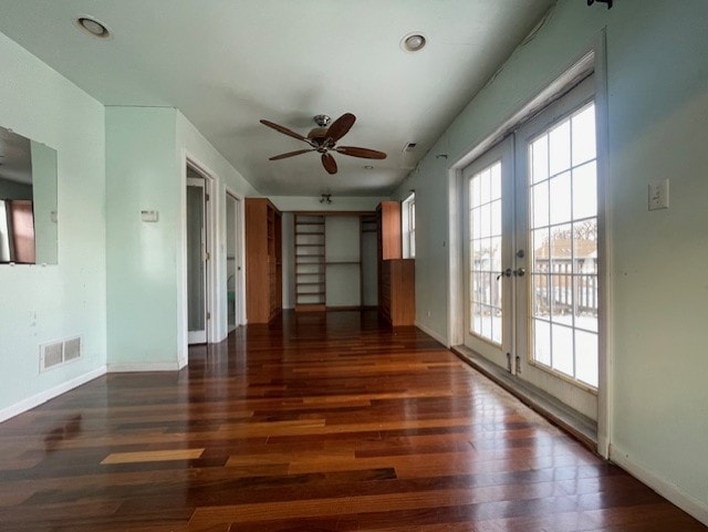 empty room featuring ceiling fan, dark hardwood / wood-style flooring, and french doors