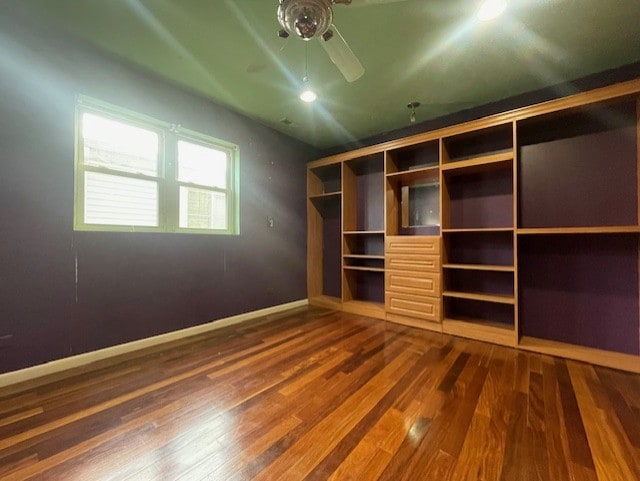 unfurnished bedroom featuring dark wood-type flooring, ceiling fan, and a closet