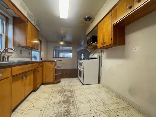 kitchen featuring sink, ceiling fan, and range with two ovens