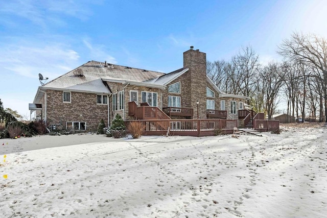 snow covered property with a deck