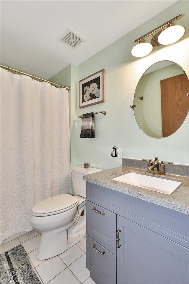 bathroom featuring vanity, tile patterned floors, and toilet