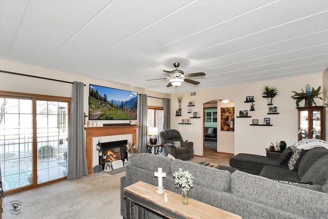 carpeted living room featuring a fireplace, plenty of natural light, and ceiling fan