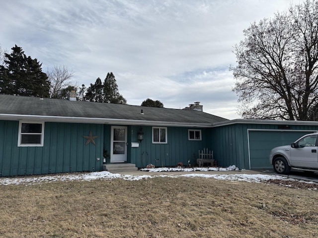 single story home with a garage and a front lawn