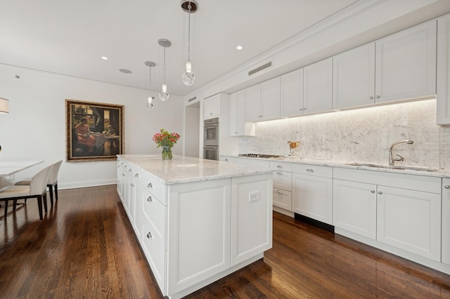 kitchen featuring white cabinetry, sink, and hanging light fixtures