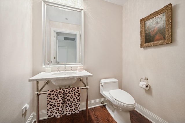 bathroom with hardwood / wood-style flooring, sink, and toilet