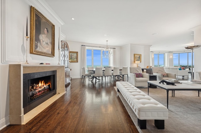 living room with crown molding, dark wood-type flooring, and a healthy amount of sunlight