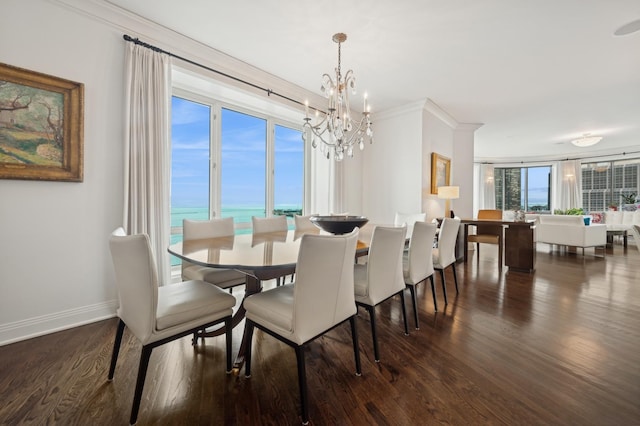 dining space with a water view, dark hardwood / wood-style flooring, a chandelier, and crown molding