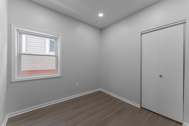 unfurnished bedroom featuring dark hardwood / wood-style floors and a closet