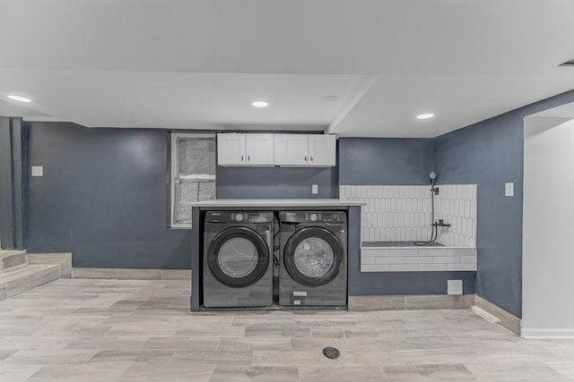 laundry room with cabinets and separate washer and dryer