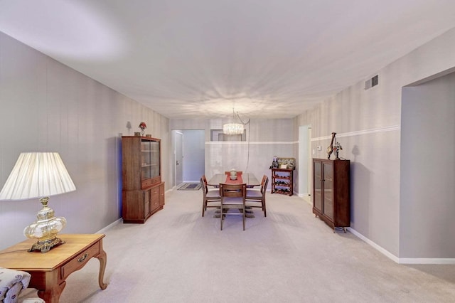 carpeted dining room featuring an inviting chandelier