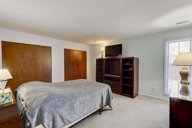 carpeted bedroom with two closets