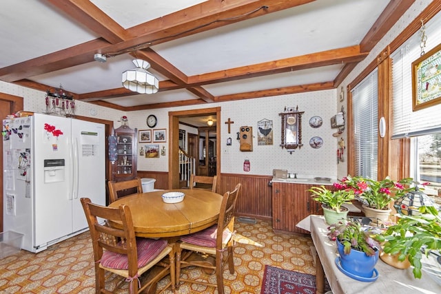 dining area featuring coffered ceiling and beam ceiling