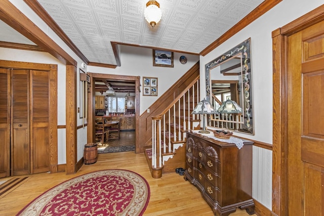 foyer featuring crown molding and light hardwood / wood-style floors