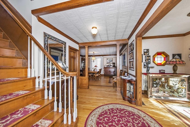 entrance foyer featuring ornamental molding and light hardwood / wood-style floors