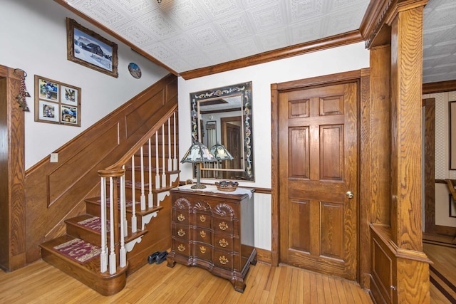 stairway with hardwood / wood-style flooring and crown molding