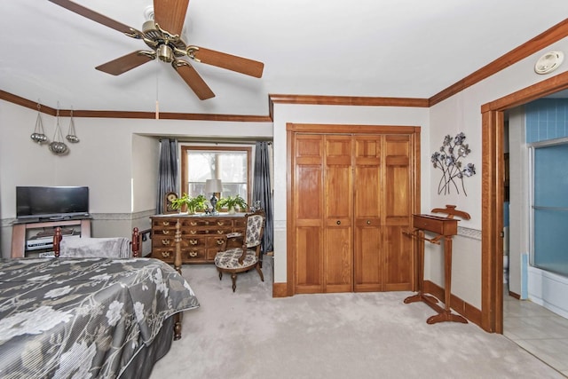 carpeted bedroom featuring ceiling fan, ornamental molding, and a closet