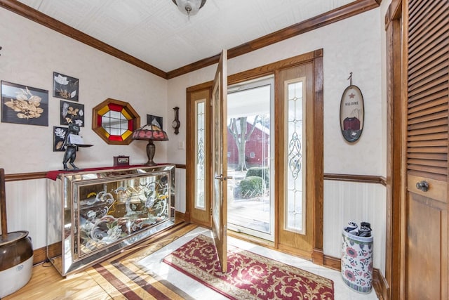 foyer entrance featuring hardwood / wood-style floors and crown molding